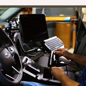 Employee servicing a radio inside an automobile