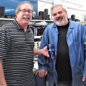Two employees smiling over a mug of coffee
