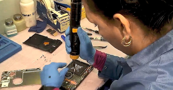 Employee performs soldering on consumer electronics